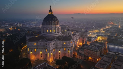 San Pietro Basilica at sunrise with city lights in Rome, Italy. Red sunrise sky at background. Aerial morning shot of St. Peter's Basilica in Vatican, Rome 