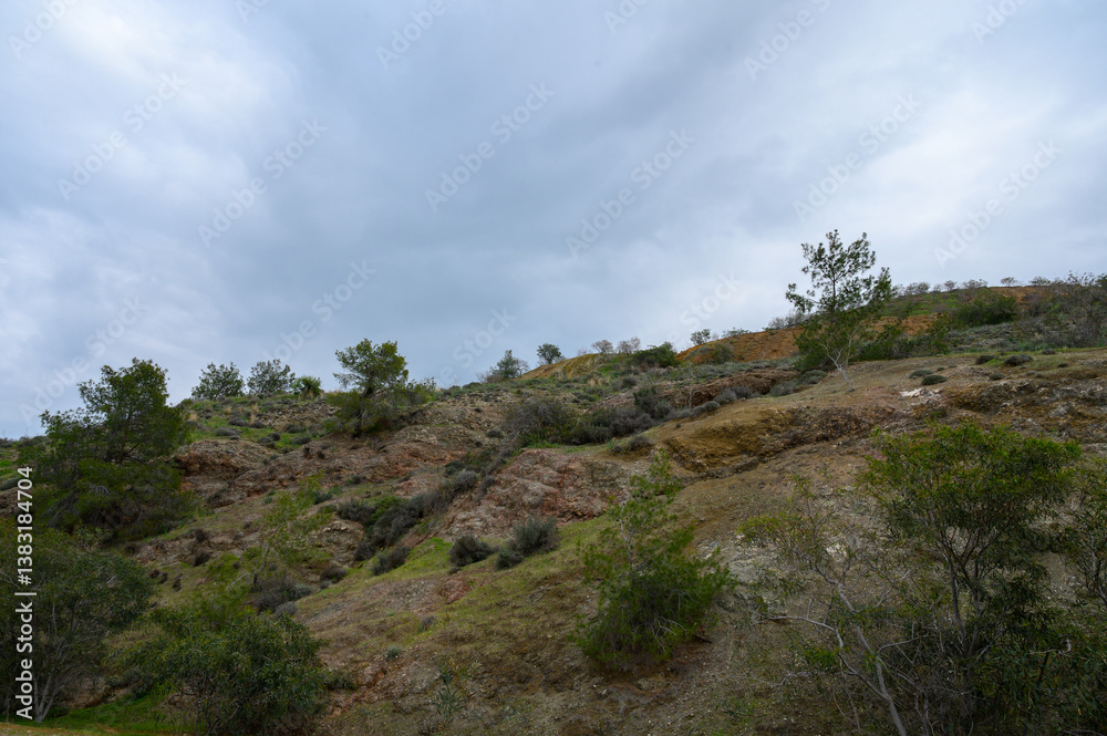 Cascading earth tones and lush greenery create a serene landscape under a cloudy sky in a tranquil natural setting Cascading earth tones and lush greenery create a serene landscape under a cloudy sky in a tranquil natural setting