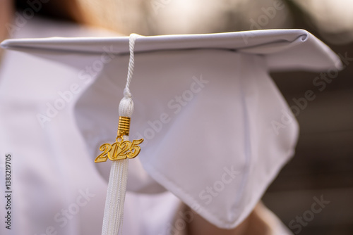 White graduation cap with tassel and gold 2025 medallion