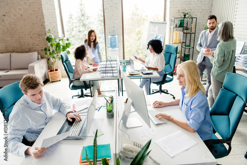 Modern office setting with diverse teamwork collaboration and professional interactions among colleagues in bright and stylish workspace