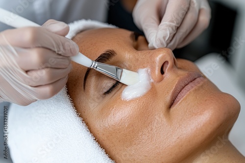 A beauty expert carefully applies a creamy facial mask on a client's skin, emphasizing beauty routines and self-indulgence in a relaxing spa environment.