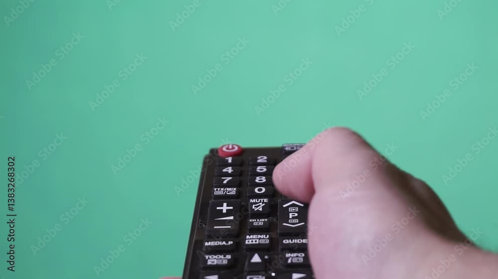 Watching TV using remote controller. Hand with the TV remote control. Green screen Watching TV using remote controller. Hand with the TV remote control. Green screen