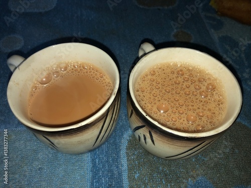  a cup of hot, frothy tea, likely a traditional Indian chai
