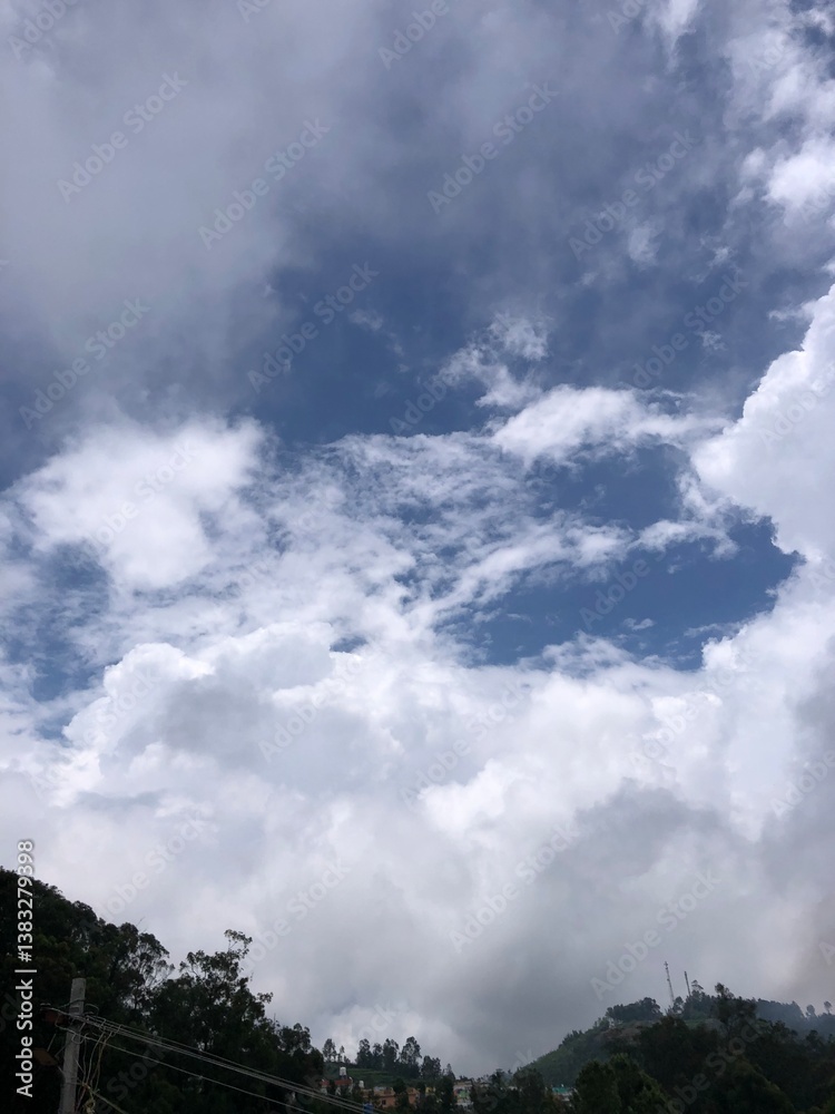 Obraz premium a beautiful view of the sky, showcasing a mix of white and gray clouds with a deep blue sky visible in between