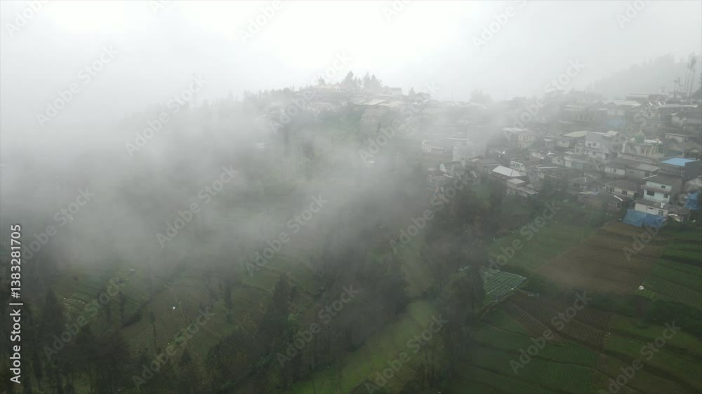 aerial view of a village in the mountains with thick fog