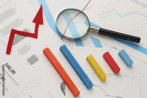 calculator and pen with blue business charts, graphs, information and reports background for financial and business concepts photo