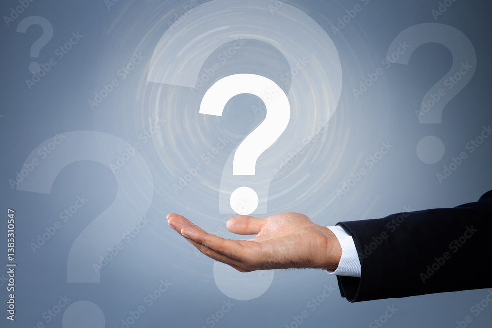 Businessman holding virtual question mark on grey background, closeup