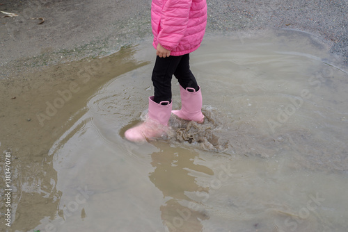 Obraz na płótnie Girl playing in a puddle of water after rain w salonie