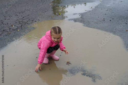 Obraz na płótnie Girl playing in a puddle of water after rain w salonie