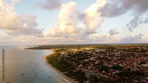 Aerial view of a coastal town with sandy beach and greenery.