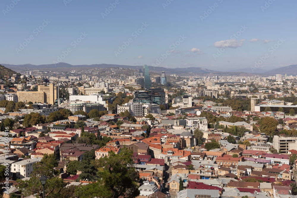 Panoramic view of Tbilisi showcasing urban landscape, historical rooftops, and modern buildings on a clear day Panoramic view of Tbilisi showcasing urban landscape, historical rooftops, and modern buildings on a clear day