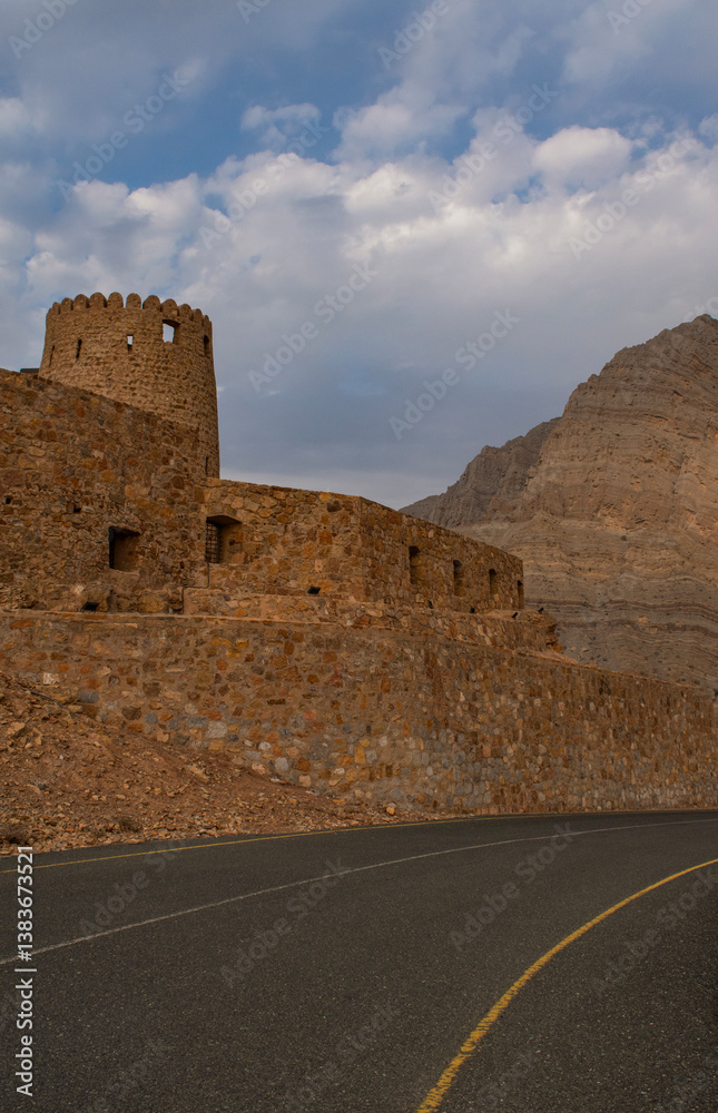 Oman, 03-04-2025: the road and the Al Qala Fort in Bukha, a fishing village in the Musandam Peninsula (Ruus Al Jibal), the northeastern point of the Arabian Peninsula south of the Strait of Hormuz