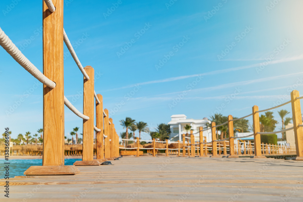 Naklejka premium Wooden pier on sea stretching into distance beyond horizon on sunny summer day. Vacation and Travel Concept.
