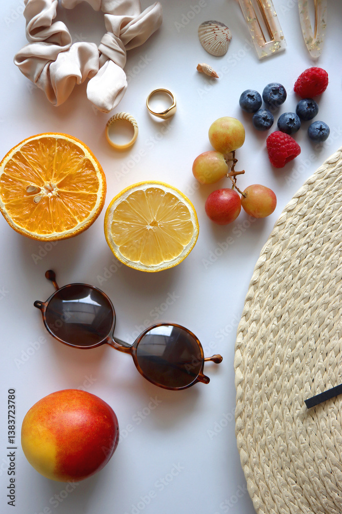Straw hat, sunglasses, seasonal fruit, seashells and colorful accessories on white backgrounds. Cute summer essentials. Flat lay.