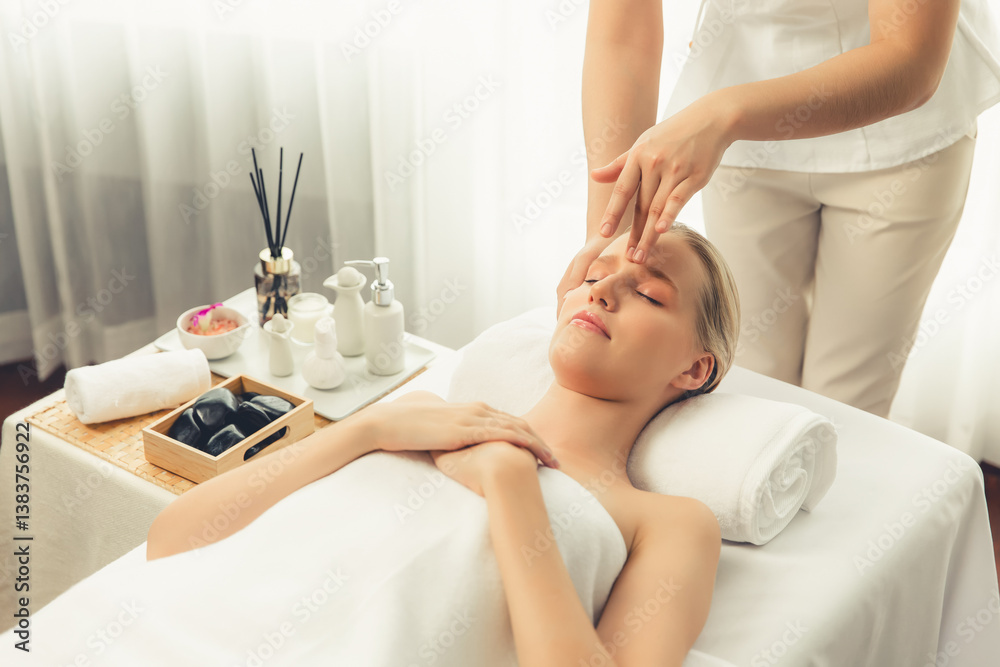 Fototapeta premium Caucasian woman enjoying relaxing anti-stress head massage and pampering facial beauty skin recreation leisure in dayspa modern light ambient at luxury resort or hotel spa salon. Quiescent