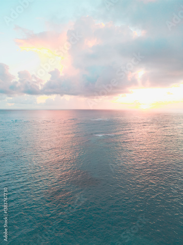 Aerial view of colorful sunrise over ocean in Punta Cana. Breathtaking scenery showcases sky painted with stunning hues, while gentle waves reflect morning light. Perfect postcard capturing tropical