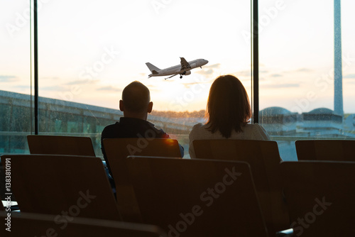 People wait in an airport lounge, silhouetted against a large window at sunset. The warm glow of the golden hour creates dramatic backlighting, highlighting their figures. The vibrant colors of the ev