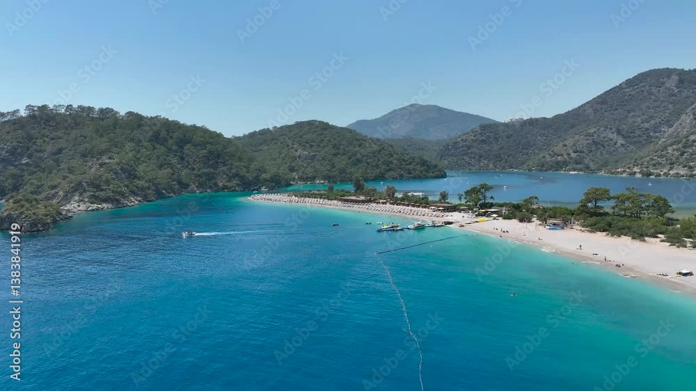 Drone scenery of Oludeniz Beach with greenery, boats, turquoise waters and green mountains Drone scenery of Oludeniz Beach with greenery, boats, turquoise waters and green mountains
