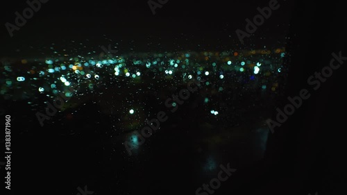 Drops of water on the window on a rainy night with lights of the city in the background, Mexico.