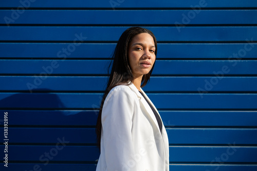 Confident Businesswoman Posing Against Blue Urban Backdrop