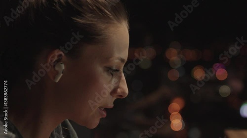 Close up portrait a woman speak on cell phone about work. Girl have call with client on background big city light. Business woman do business. Young woman talking on phone in apartment at night. 