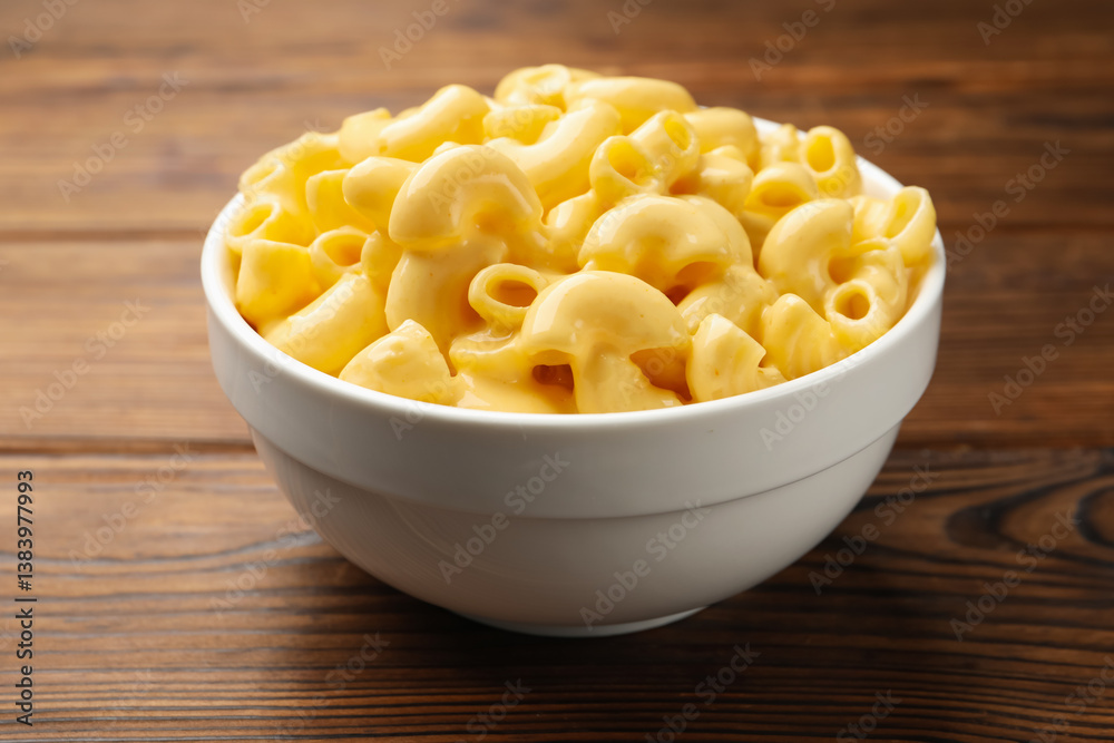 Delicious macaroni and cheese on wooden table, closeup