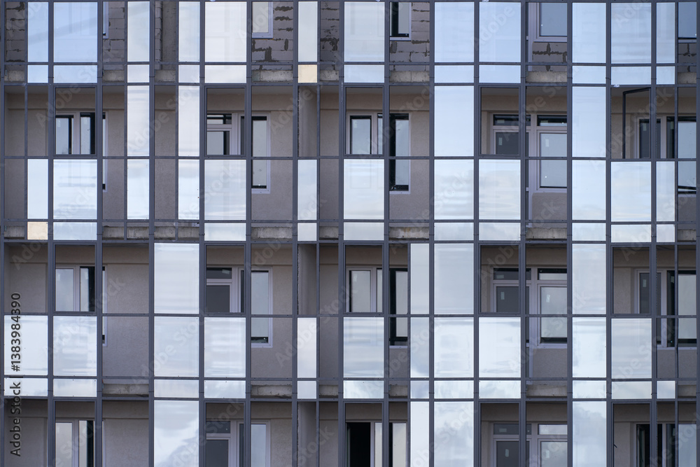 Construction of a multi-storey building with a mirrored facade. A fragment of several floors.