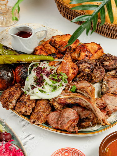 Azerbaijani kebab assortment in big plate. Lamb chops kebab, lula kebab, chicken kebab, vegetables kebab