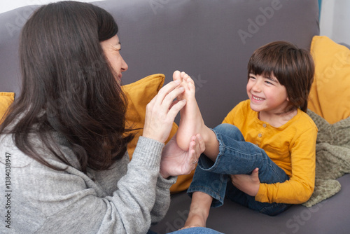 Photography Smiling mother and son share a moment of complicity on the sofa