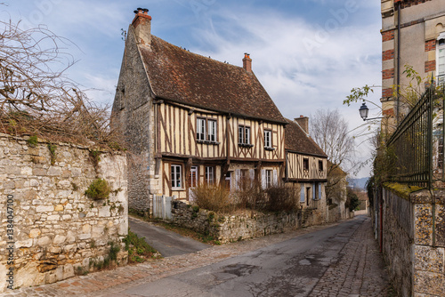 Fototapeta Naklejka Na Ścianę i Meble -  A small town street with a stone wall on the side. Medieval house in Europe.