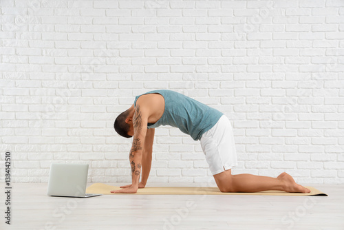 Young man with laptop doing...