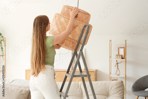 Young woman screwing light ...