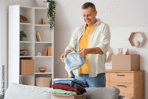 Mature man unpacking box wi...