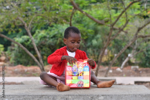 beautiful african Child playing with colorful toy blocks