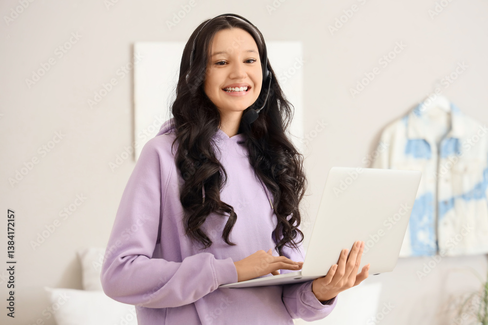 Teenage girl with laptop working online in bedroom Teenage girl with laptop working online in bedroom