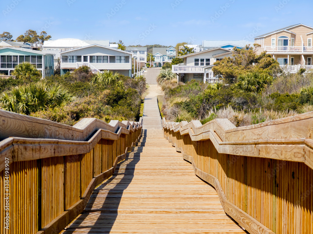 Long wood bridge leading to beach houses on the East Coast during a sunny day with beautiful blue sky