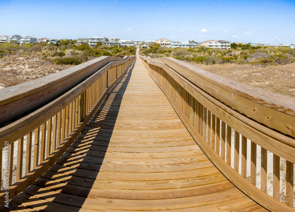 Long wood bridge leading to beach houses on the East Coast during a sunny day with beautiful blue sky