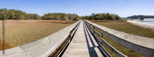 Obraz na płótnie Wood bridge spanning across acres of golden reeds and marsh in a classic South Carolina landscape setting of trees w salonie