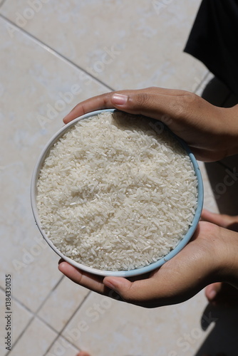 both hands hold the rice in the bowl