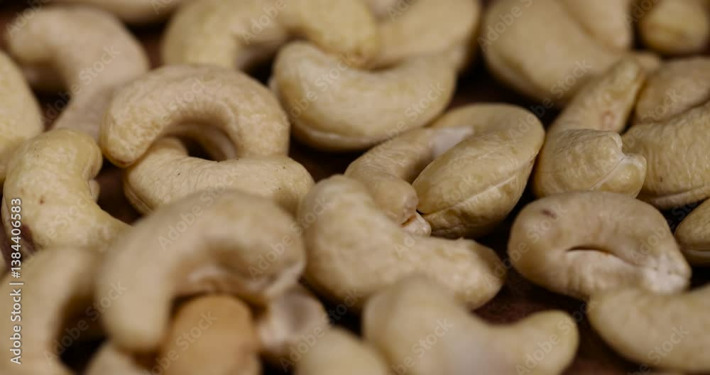 cashew are scattered on a larch board, raw unroasted cashew nuts are healthy and allowed for vegans. cashew are scattered on a larch board, raw unroasted cashew nuts are healthy and allowed for vegans.