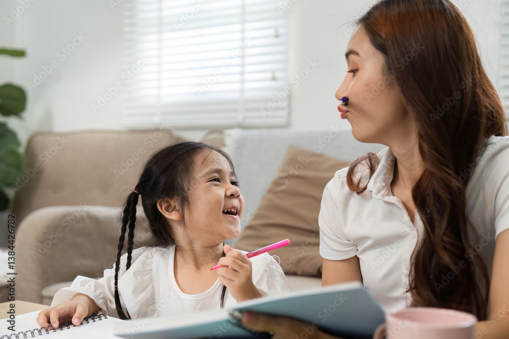 Joyful Learning and Fun Moments. A mother and daughter share laughs during study time at home. Joyful Learning and Fun Moments. A mother and daughter share laughs during study time at home.