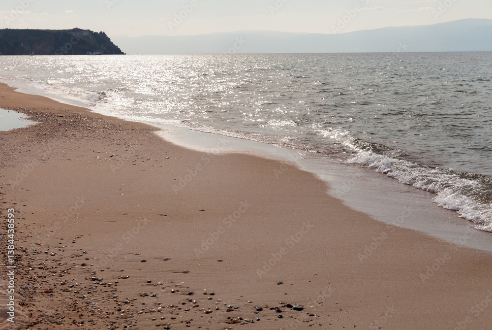 Lake Baikal on hot summer day in afternoon. Sandy beach of Saraiskiy Bay on Olkhon Island is famous for its warm and shallow waters. Summer travel and outdoors. Scenic seascape. Nature background Lake Baikal on hot summer day in afternoon. Sandy beach of Saraiskiy Bay on Olkhon Island is famous for its warm and shallow waters. Summer travel and outdoors. Scenic seascape. Nature background