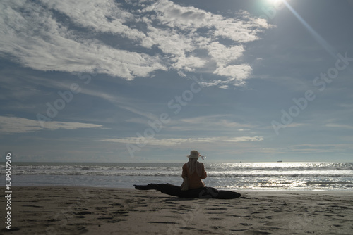 A woman sits alone and enjoys the view of the beach
