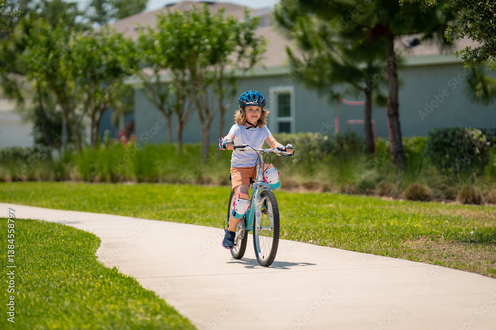 Kid riding bike in a helmet. Child with a childs bike and in protective helmet. Happy kid boy having fun in summer park with a bicycle. Bike helmet, bicycle safety, cycling accessories.