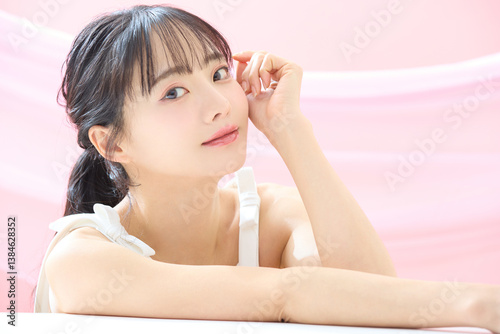ピンク背景で撮影をした若い女性の爽やかな美容イメージ