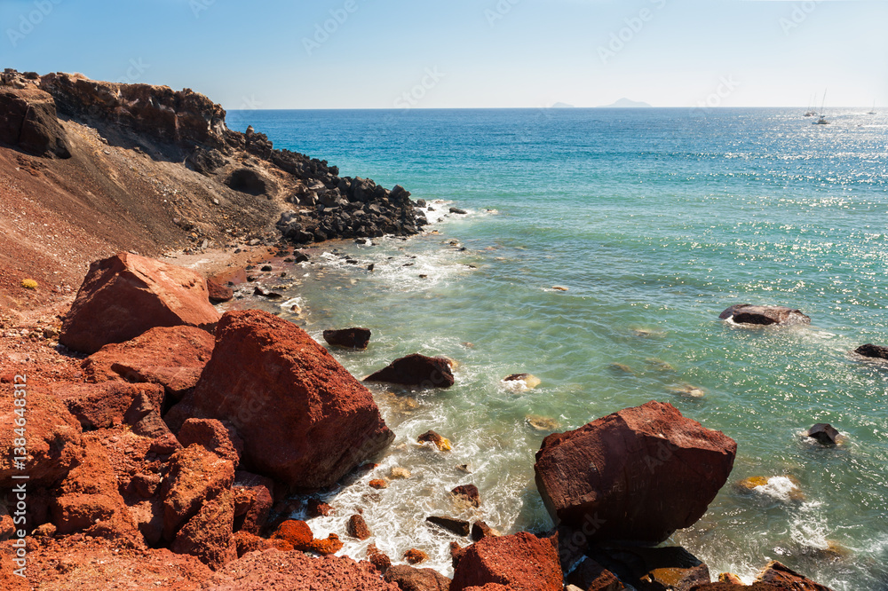 Red beach in Santorini island, Greece. Red volcanic rocks and the blue sea.
