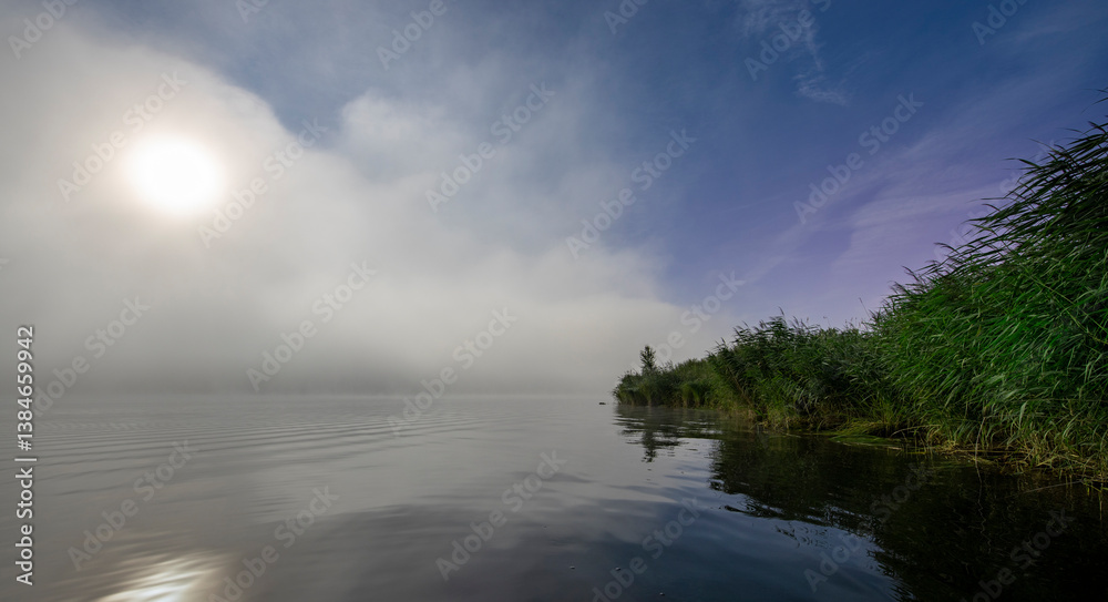A foggy lake with a full moon reflecting on the water A foggy lake with a full moon reflecting on the water