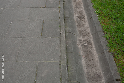 Wallpaper Mural Urban sidewalk with concrete slabs and shallow drainage channel along the lawn. Typical pedestrian infrastructure and water runoff system in a city, top-down view Torontodigital.ca