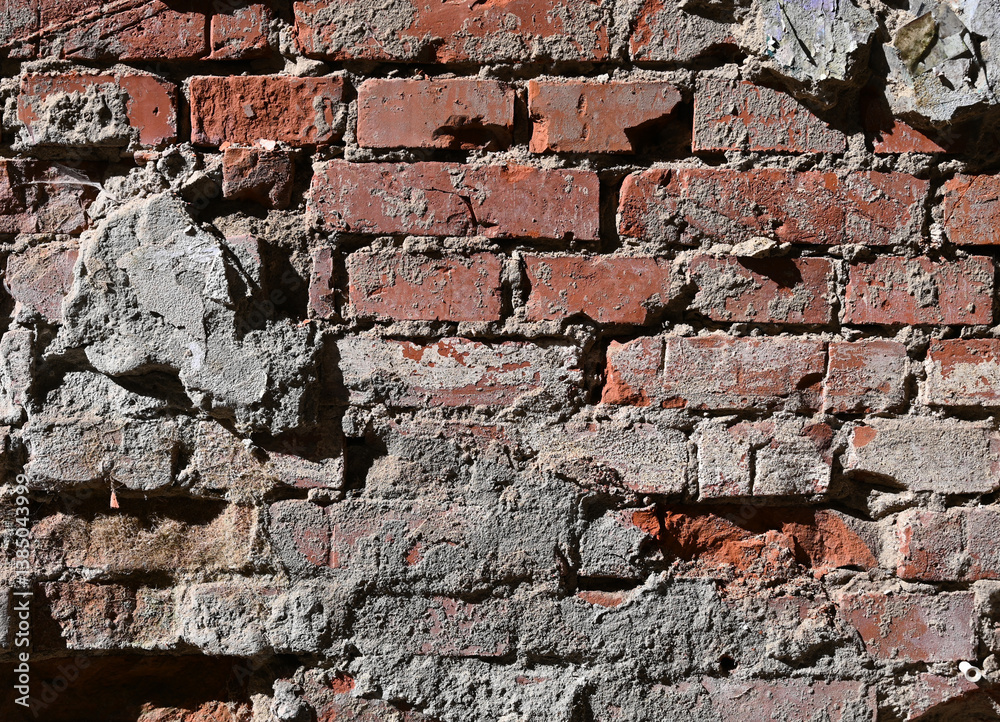 Weathered brick wall with worn textures and exposed mortar in urban setting showing signs of age Weathered brick wall with worn textures and exposed mortar in urban setting showing signs of age