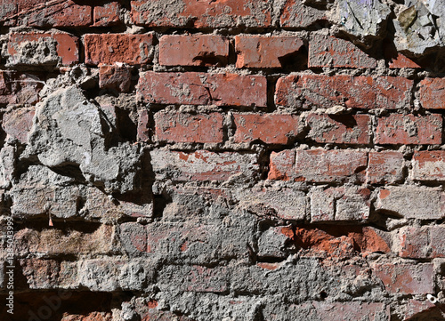 Obraz na płótnie Weathered brick wall with worn textures and exposed mortar in urban setting showing signs of age w salonie
